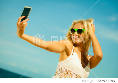 Happy girl taking self picture with smartphone Happy girl taking self picture with smartphone 127971193