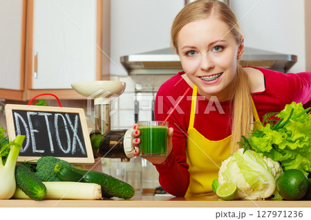 Woman holding vegetable juice and detox sign 127971236