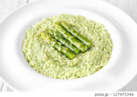 Asparagus risotto served in white plate with whole spears on top Asparagus risotto served in white plate with whole spears on top 127971348