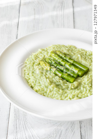 Asparagus risotto served in white plate with whole spears on top Asparagus risotto served in white plate with whole spears on top 127971349