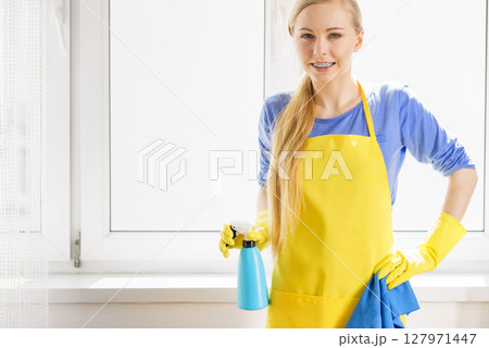 Woman cleaning window at home 127971447