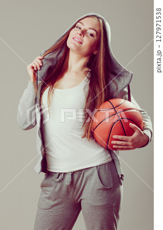 Sporty teen girl in hood holding basketball. Sporty teen girl in hood holding basketball. 127971538