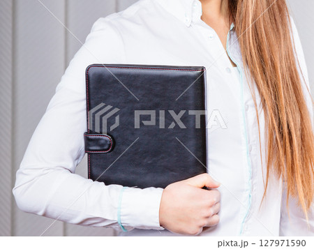 Young woman office worker hold case with files. Young woman office worker hold case with files. 127971590