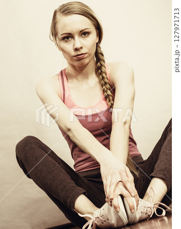 Sad depressed young teenage girl sitting by wall Sad depressed young teenage girl sitting by wall 127971713