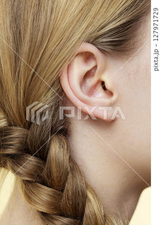 Close up on female ear and braid hair Close up on female ear and braid hair 127971729