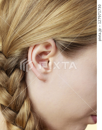 Close up on female ear and braid hair 127971730