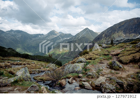 Mountain landscape with rocky trail and alpine stream in the Austrian Alps 127971912