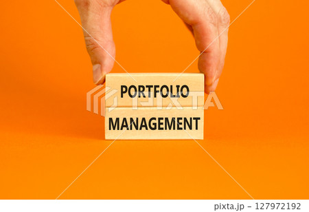 Portfolio management symbol. Concept words Portfolio management on beautiful wooden block. Beautiful orange paper background. Businessman hand. Business Portfolio management concept. Copy space. Portfolio management symbol. Concept words Portfolio management on beautiful wooden block. Beautiful orange paper background. Businessman hand. Business Portfolio management concept. Copy space. 127972192