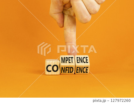Competence and confidence symbol. Concept word Competence Confidence on wooden cubes. Businessman hand. Beautiful orange table orange background. Business competence confidence concept. Copy space. Competence and confidence symbol. Concept word Competence Confidence on wooden cubes. Businessman hand. Beautiful orange table orange background. Business competence confidence concept. Copy space. 127972260