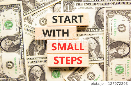 Start with small steps symbol. Concept words phrase Start with small steps on beautiful blocks. Dollar bills. Beautiful dollar bills background. Business Start with small steps concept. Copy space 127972298