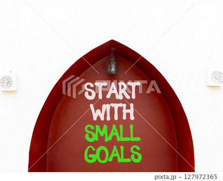 Start with small goals symbol. Concept words phrase Start with small goals on beautiful brown wall. Beautiful white wall background. Business Start with small goals concept. Copy space. 127972365