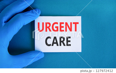 Urgent care symbol. Concept words Urgent care on beautiful white card. Doctor's hand in blue medical glove. Beautiful blue background. Medical healthy lifestyle urgent care concept. 127972412