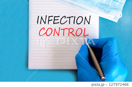 Infection control symbol. Concept words Infection control on beautiful white note. Doctor's hand in blue medical glove. Beautiful blue background. Medical healthy lifestyle infection control concept. 127972466