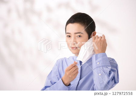 マスクを外すミドル女性 127972558