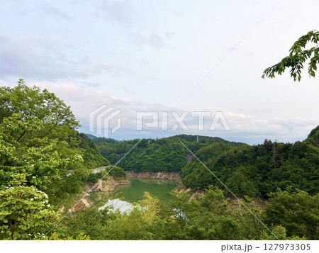 緑に囲まれたダム湖 127973305
