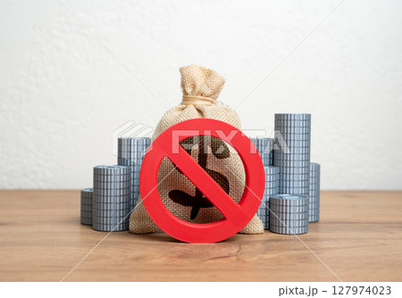 The NO prohibition sign covers the dollar money bag and stacks of coins. Freezing or confiscation of financial assets. Anti-money laundering actions, asset seizure, or economic retaliation. The NO prohibition sign covers the dollar money bag and stacks of coins. Freezing or confiscation of financial assets. Anti-money laundering actions, asset seizure, or economic retaliation. 127974023