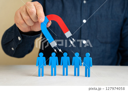 A man with a magnet attracts people. Leadership charisma. Attracting clients or hiring. Recruitment strategies, business outreach, customer acquisition. 127974058