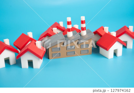An industrial plant surrounded by houses. Public demand for the removal of dirty and noisy industry outside the growing area of the city. Pushback against pollution, noise, zoning laws 127974162