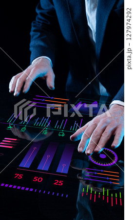 Executives using smart digital table to analyze interactive business data charts 127974292