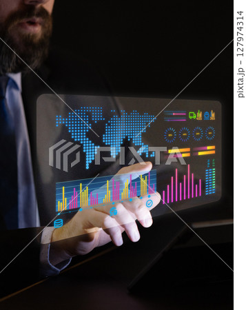 Businessman uses holographic world data dashboard with graphs and analytics. Data visualization Businessman uses holographic world data dashboard with graphs and analytics. Data visualization 127974314