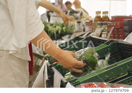 スーパーの野菜コーナーで買い物をする女性 127974709