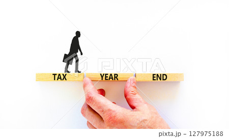 Tax year end symbol. Concept words Tax year end on beautiful wooden blocks. Beautiful white background. Businessman hand. Business tax year end concept. Copy space. Tax year end symbol. Concept words Tax year end on beautiful wooden blocks. Beautiful white background. Businessman hand. Business tax year end concept. Copy space. 127975188