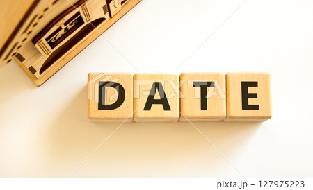 Date symbol. Concept word Date on beautiful wooden blocks. Beautiful wooden house. Beautiful white table white background. Business and date concept. Copy space. 127975223