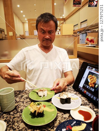 回転寿司で寿司を食べる中国人 回転寿司で寿司を食べる中国人 127975251