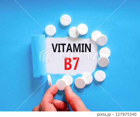 Vitamin B7 biotin symbol. Concept words Vitamin B7 on beautiful white paper. White pills tablets. Doctor's hand. Beautiful blue background. Medical healthy lifestyle Vitamin B7 concept. 127975340
