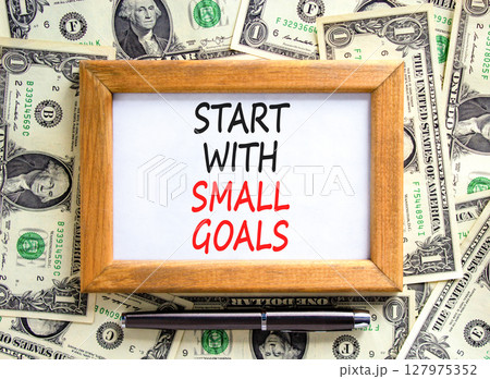 Start with small goals symbol. Concept words phrase Start with small goals on beautiful white note. Dollar bills. Beautiful dollar bills background. Business Start with small goals concept. Copy space Start with small goals symbol. Concept words phrase Start with small goals on beautiful white note. Dollar bills. Beautiful dollar bills background. Business Start with small goals concept. Copy space 127975352