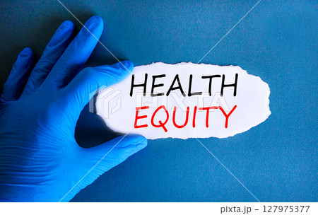 Health equity symbol. Concept words Health equity on beautiful white paper. Doctor's hand in blue medical glove. Beautiful blue background. Medical healthy lifestyle health equity concept. 127975377