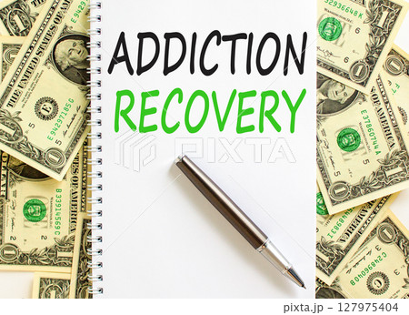 Addiction recovery symbol. Concept words Addiction recovery on beautiful white note. Beautiful background from dollar bills. Black pen. Psychology addiction recovery concept. Copy space. 127975404