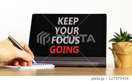 Keep your focus going symbol. Concept words Keep your focus going on beautiful black tablet. Beautiful white background. Businessman hand. Business and keep your focus going concept. Copy space. 127975434