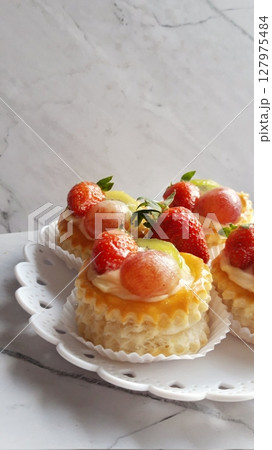 Mini burnt cheesecake with a caramelized top and rich, creamy center, topped with fresh fruits for a perfect balance of sweetness and tartness in every bite. 127975484