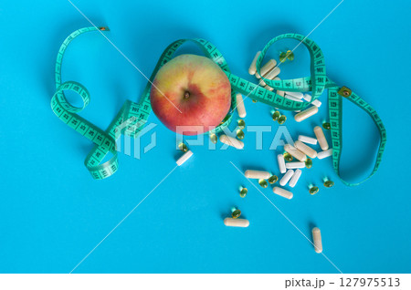Weight Loss Pills and Measuring Tape, Diet Supplements Capsules, Obesity Lose Tablets, Color Drugs Pile 127975513