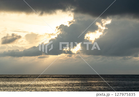 Cloud layers above calm sea reflect soft light at dusk near La Digue island, Seychelles Cloud layers above calm sea reflect soft light at dusk near La Digue island, Seychelles 127975835