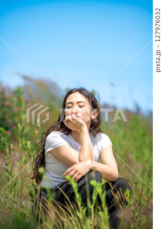 青空のもとでリラックスする若い女性 青空のもとでリラックスする若い女性 127976032
