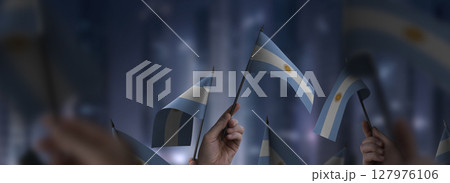 Argentina flags in their hands on a blurred urban background 127976106