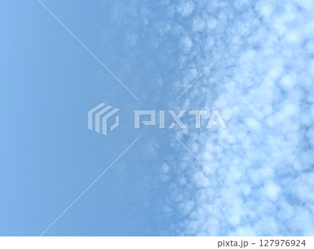 Pretty blue sky with bubble style white clouds floating atmosphere gentle skyscape 127976924