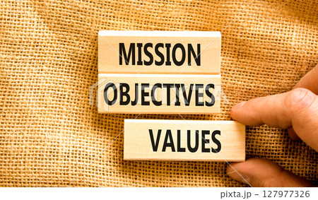 Mission objectives values symbol. Concept words Mission Objectives Values on beautiful blocks. Beautiful canvas background. Businessman hand. Business mission objectives values concept. Copy space. 127977326