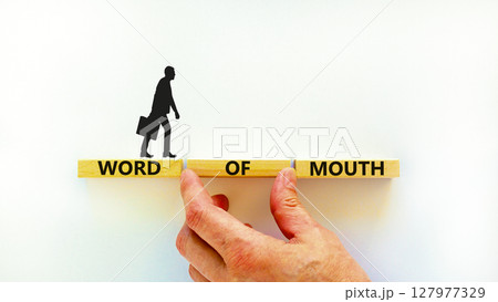 Word of mouth symbol. Concept words Word of mouth on wooden blocks on a beautiful white table white background. Businessman hand. Business, finacial and word of mouth concept. Copy space. 127977329