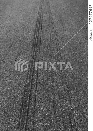 Abstract asphalt street road background with black tire marks on race track, Texture and background car automobile and automotive skid tire marks. 127977697