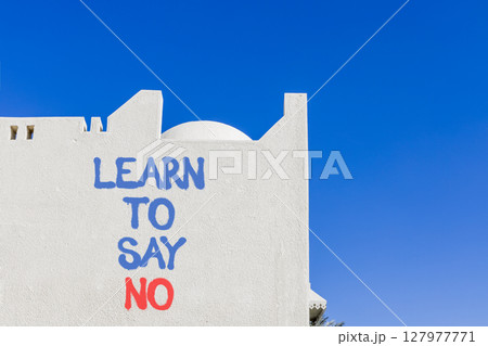 Learn to say no symbol. Concept words phrase Learn to say no on beautiful white wall. Beautiful white wall and blue sky background. Business psychological Learn to say no concept. Copy space. Learn to say no symbol. Concept words phrase Learn to say no on beautiful white wall. Beautiful white wall and blue sky background. Business psychological Learn to say no concept. Copy space. 127977771