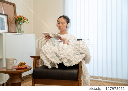 毛布をかぶってリラックスしている若い女性 127978051