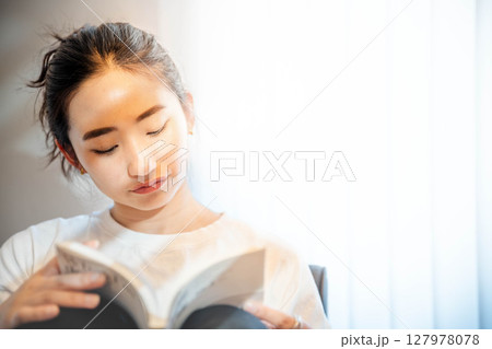 毛布をかぶってリラックスしている若い女性 毛布をかぶってリラックスしている若い女性 127978078