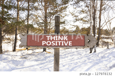 Think positive symbol. Concept words Think positive on beautiful wooden road sign. Beautiful forest snow blue sky background. Business, motivational think positive thinking concept. Copy space. Think positive symbol. Concept words Think positive on beautiful wooden road sign. Beautiful forest snow blue sky background. Business, motivational think positive thinking concept. Copy space. 127978132