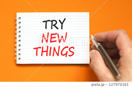Try new things symbol. Concept words Try new things on beautiful white note. Beautiful orange background. Businessman hand with pen. Business motivational lifestyle try new things concept. Copy space. 127978161