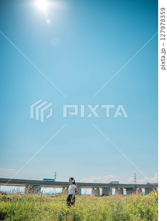 スマホで音楽を聴く女性 127978359