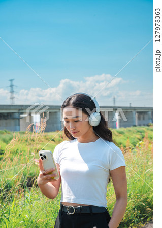 スマホで音楽を聴く女性 127978363