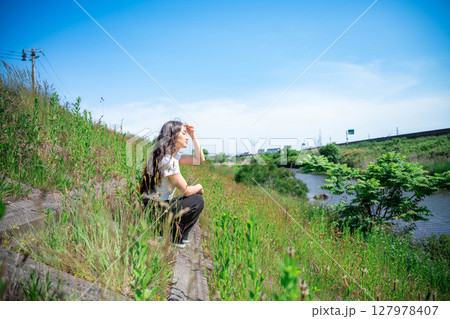 青空の下でリラックスしている若い女性 127978407